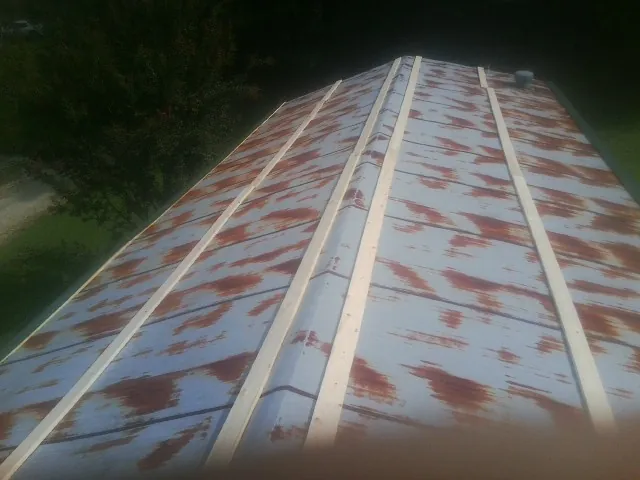 Rusted metal roof panels with new wood purlins before replacement — Storm Damage Roof Repair in Karval by Roofing Brothers