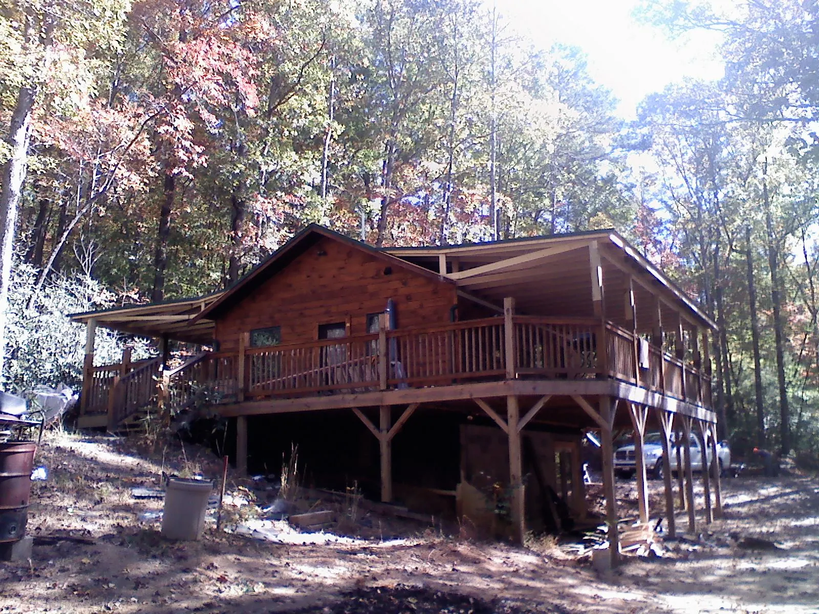 Log cabin with a wraparound porch and metal roof in the fall in Karval