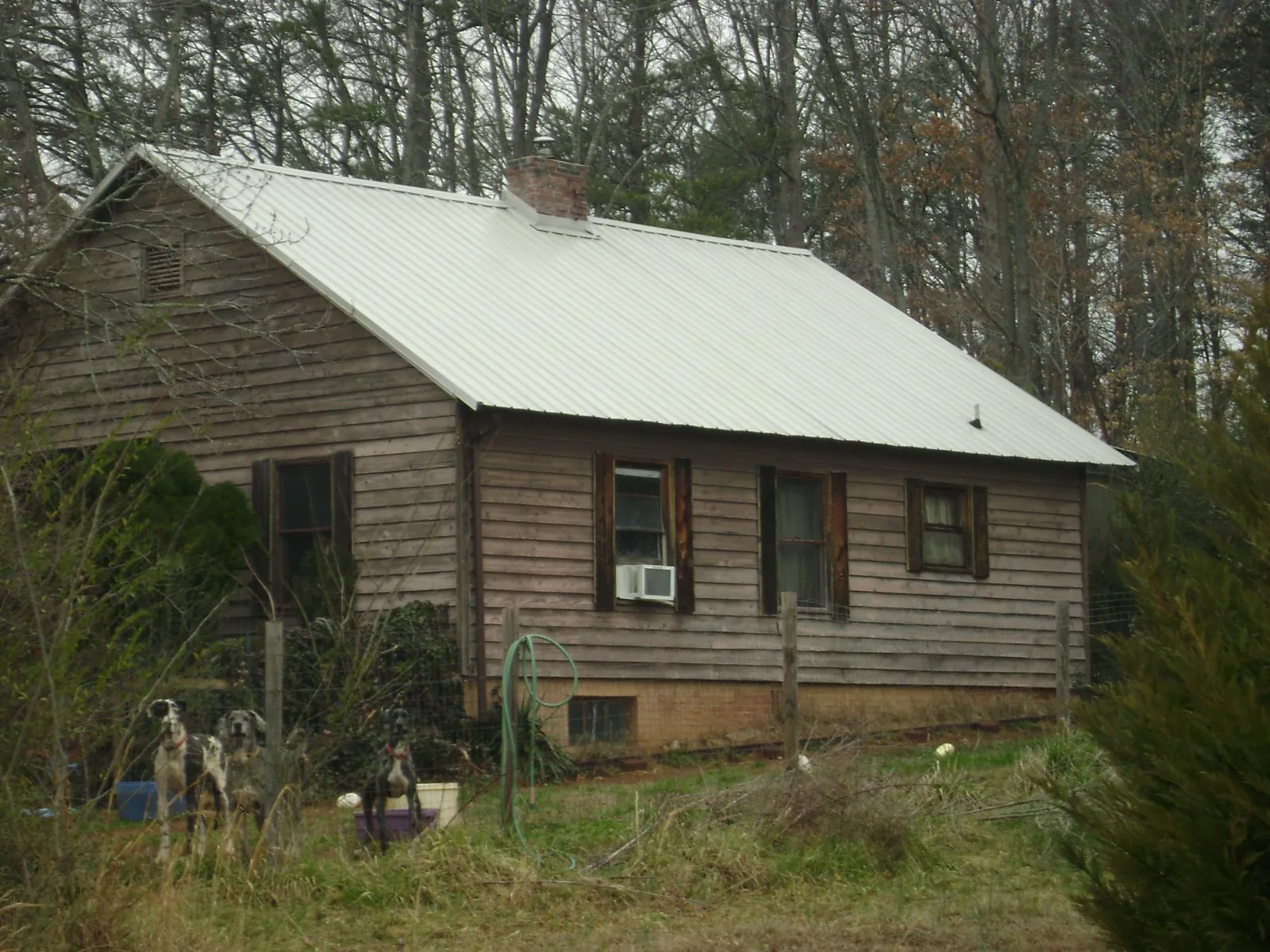 White metal roof on an old wood sided farmhouse, from a Metal Roof Installation job in Karval